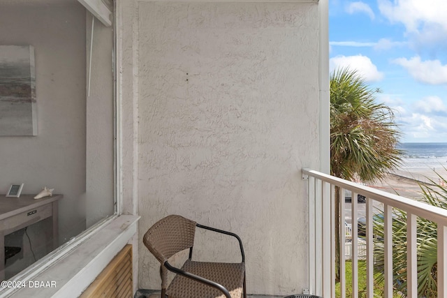 balcony with a water view and a beach view