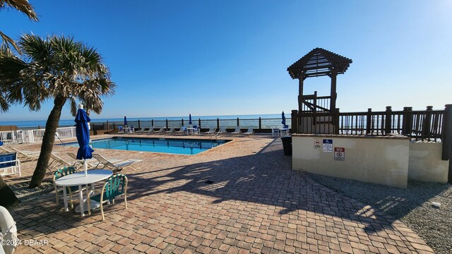 view of pool with a water view and a patio area