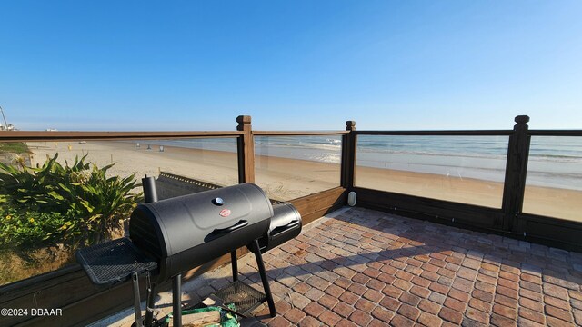 view of patio with a beach view and a water view