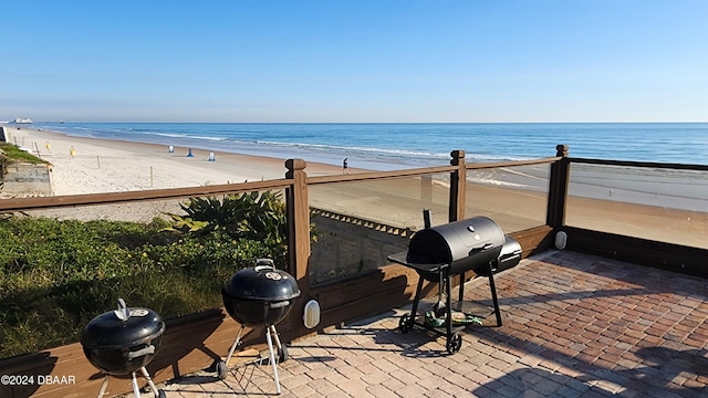 1233 N Atlantic Ave Unit 212, Daytona Beach, FL 32118 - view of patio featuring a balcony, view of water and beach, and a grill