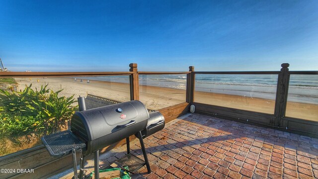 view of patio featuring a water view and a beach view