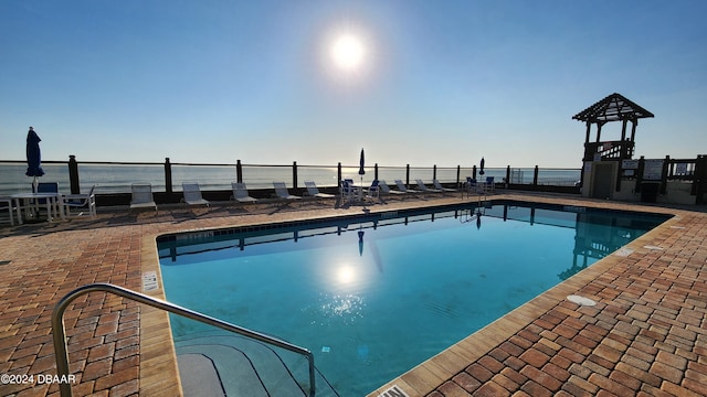 view of pool with a patio and a water view