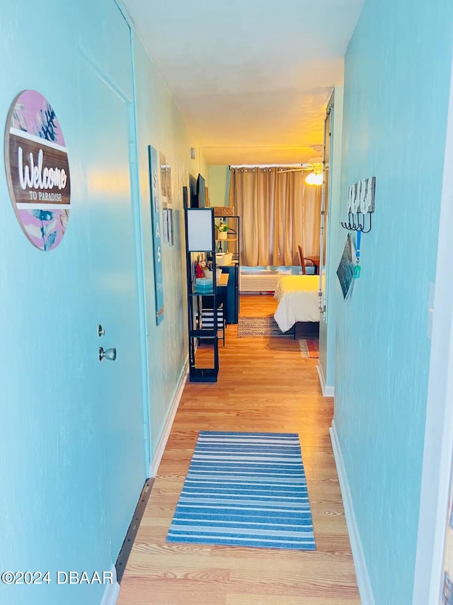 hallway with hardwood / wood-style flooring