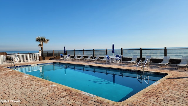 1233 N Atlantic Ave Unit 212, Daytona Beach, FL 32118 - community pool featuring a patio area, fence, and a water view