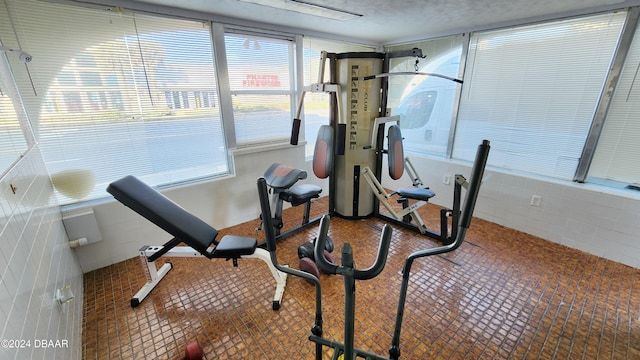 workout room featuring tile walls