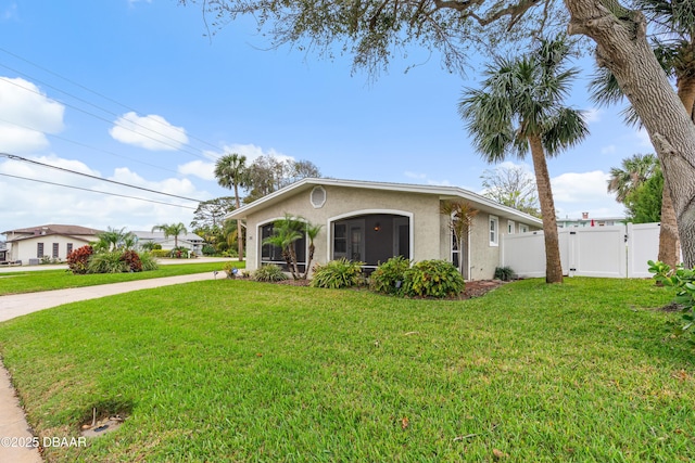 view of front of property with stucco siding, concrete driveway, a front yard, a gate, and fence