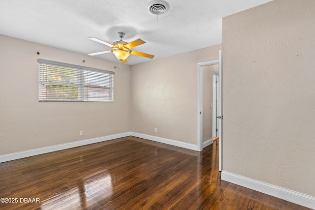 empty room with baseboards, visible vents, ceiling fan, and wood finished floors