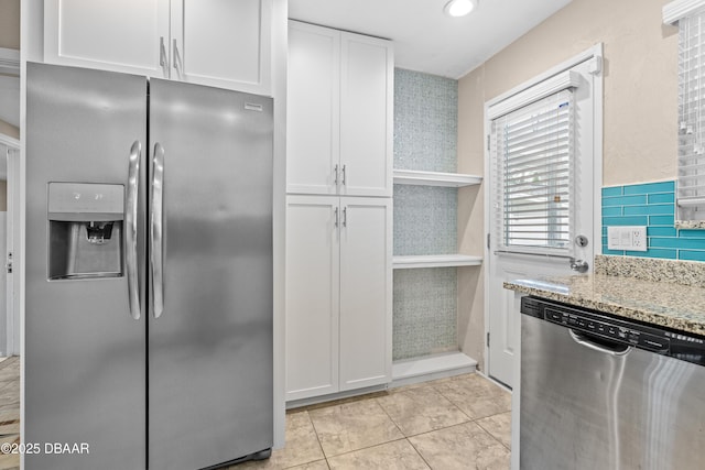 kitchen featuring light stone countertops, appliances with stainless steel finishes, white cabinets, and light tile patterned flooring