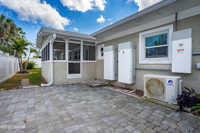 exterior space with ac unit, fence, and a sunroom