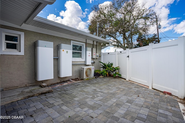 view of patio with ac unit, fence, and a gate