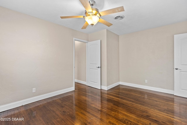 spare room featuring visible vents, ceiling fan, baseboards, and wood finished floors