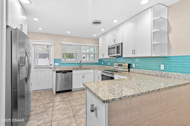 kitchen with visible vents, white cabinets, stainless steel appliances, open shelves, and a sink