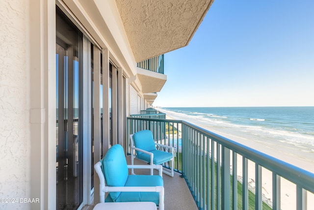 balcony with a water view and a view of the beach