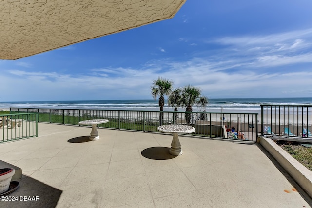 exterior space with a beach view, a water view, and a balcony