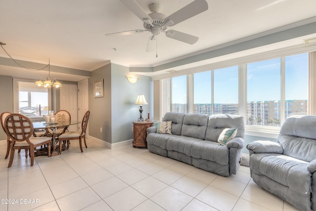 tiled living room featuring ceiling fan with notable chandelier and ornamental molding