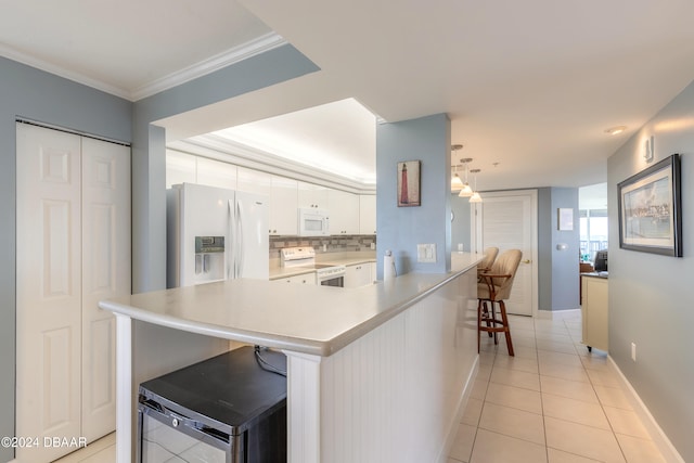 kitchen with decorative backsplash, a kitchen bar, white appliances, light tile patterned floors, and white cabinetry