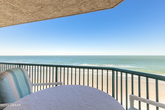 balcony with a water view and a view of the beach