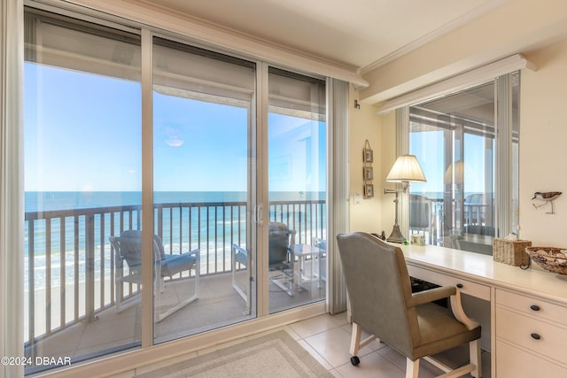 tiled home office with a water view, a view of the beach, and ornamental molding