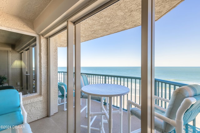 sunroom / solarium with a beach view, a water view, and a healthy amount of sunlight