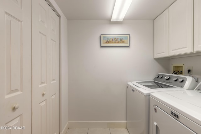 laundry area with separate washer and dryer, light tile patterned flooring, and cabinets