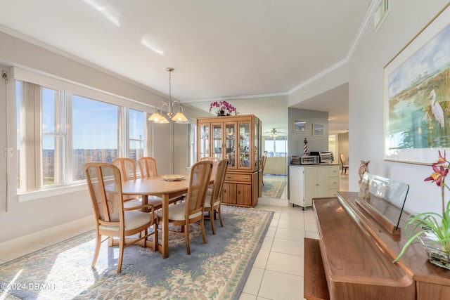 dining area with light tile patterned flooring, crown molding, and a chandelier