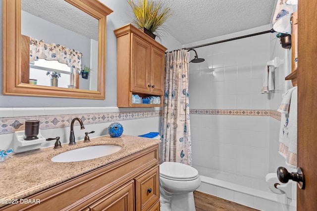 bathroom with toilet, vanity, a textured ceiling, and curtained shower