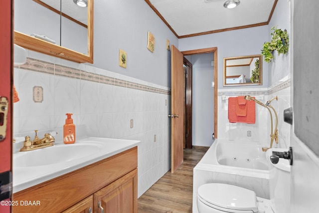 full bathroom with toilet, vanity, tile walls, wood-type flooring, and ornamental molding