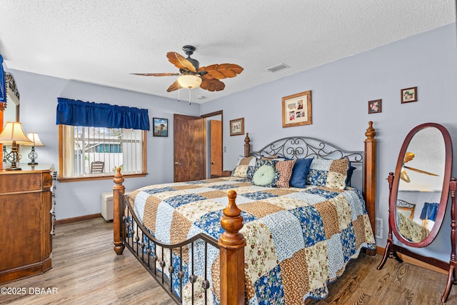 bedroom featuring ceiling fan, a textured ceiling, and hardwood / wood-style flooring