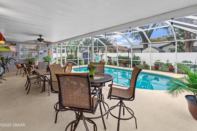 view of swimming pool with ceiling fan, a storage shed, glass enclosure, and a patio