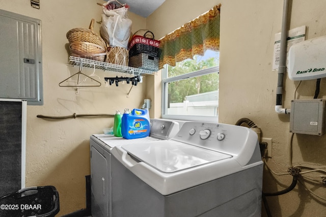 washroom with electric panel and washer and clothes dryer