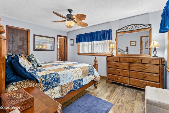 bedroom with a textured ceiling, ceiling fan, and light hardwood / wood-style flooring