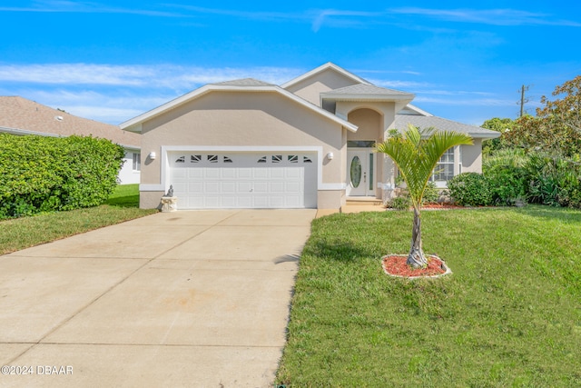 view of front of home with a front yard and a garage