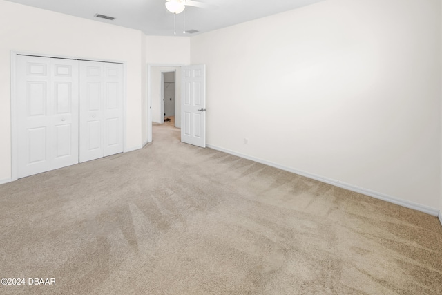 unfurnished bedroom with ceiling fan, carpet floors, and a closet