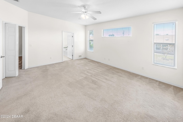 empty room with ceiling fan and light carpet