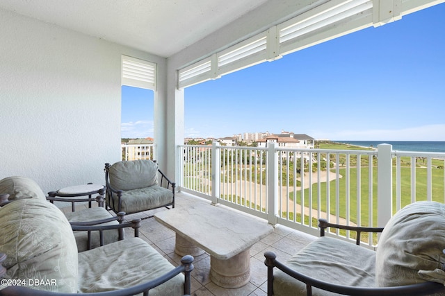 balcony featuring a beach view and a water view