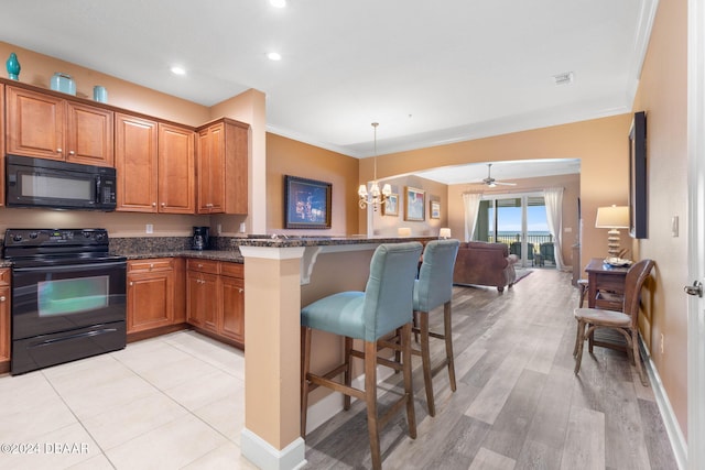 kitchen with a breakfast bar, black appliances, ceiling fan with notable chandelier, crown molding, and light wood-type flooring