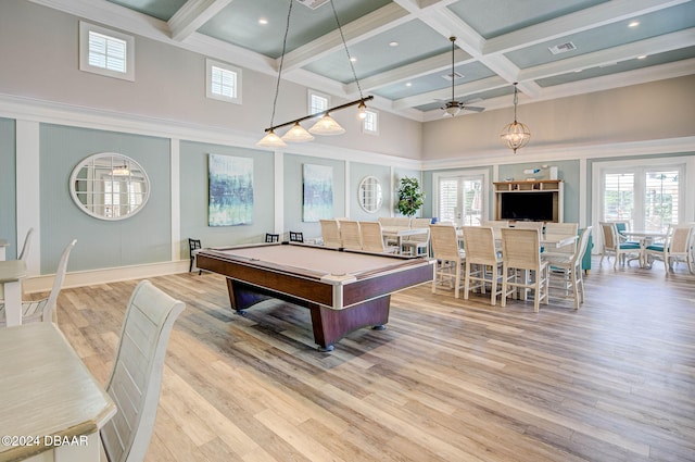 recreation room featuring a towering ceiling, light wood-type flooring, coffered ceiling, beamed ceiling, and ceiling fan