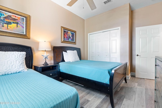 bedroom featuring hardwood / wood-style flooring, ceiling fan, and a closet