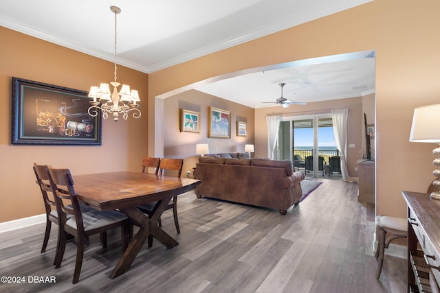 dining room featuring wood-type flooring, crown molding, and ceiling fan with notable chandelier