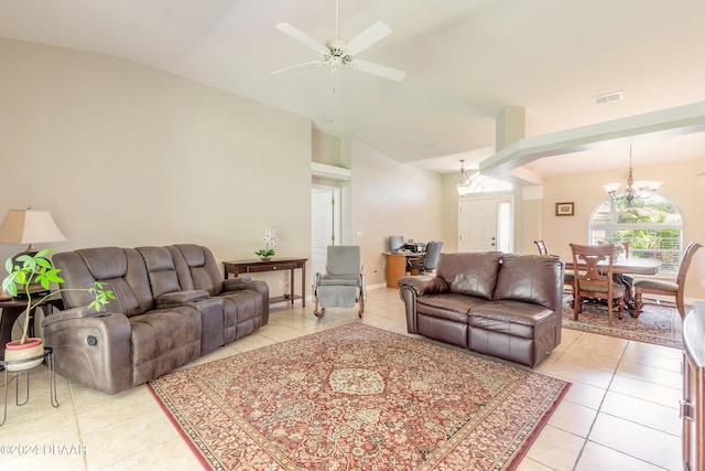 living room featuring ceiling fan with notable chandelier, light tile patterned floors, and vaulted ceiling