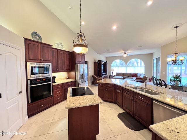 kitchen with light tile patterned floors, sink, hanging light fixtures, stainless steel appliances, and a center island