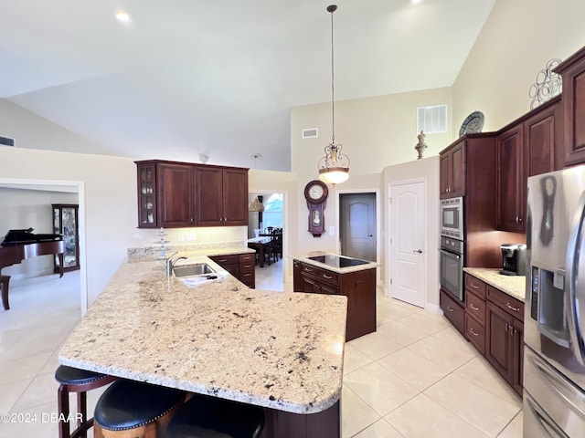 kitchen featuring appliances with stainless steel finishes, sink, a kitchen bar, hanging light fixtures, and kitchen peninsula