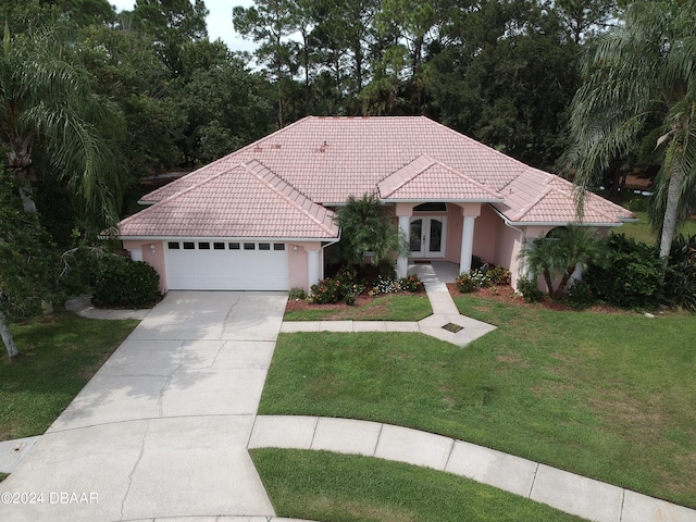6382 Longlake Dr, Port Orange, FL 32128 - mediterranean / spanish home with french doors, a tiled roof, a front yard, driveway, and an attached garage