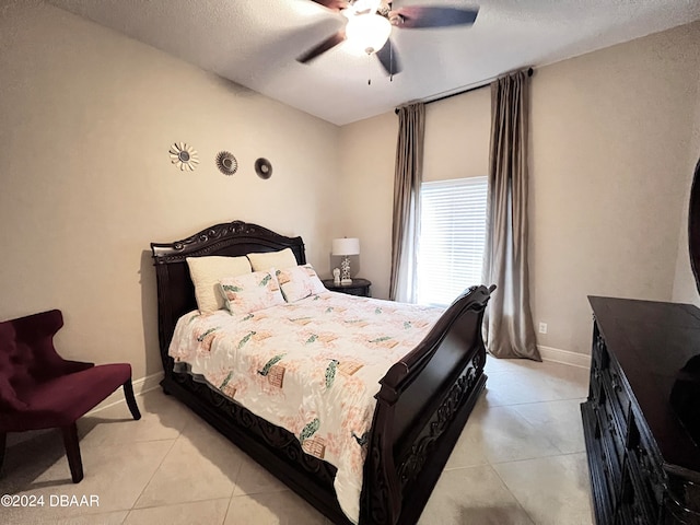 bedroom featuring light tile patterned floors, a textured ceiling, and ceiling fan