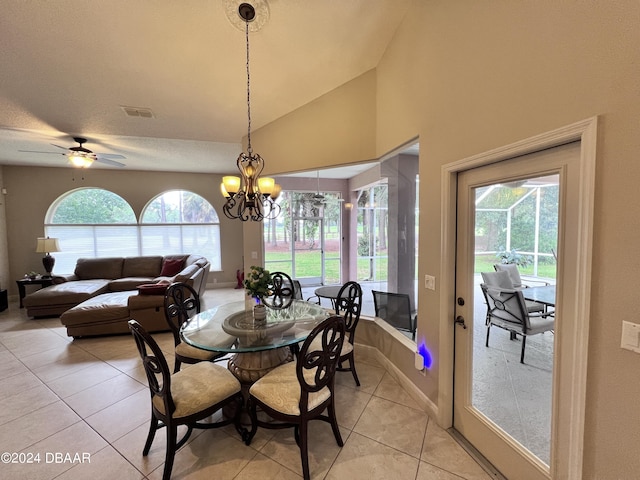 tiled dining room with lofted ceiling, plenty of natural light, and a chandelier