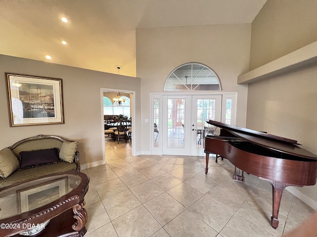 foyer featuring french doors, light tile patterned flooring, high vaulted ceiling, and a notable chandelier