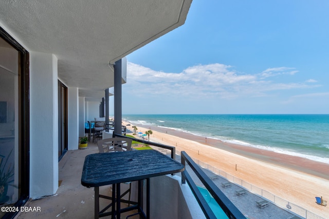 balcony featuring a water view and a beach view