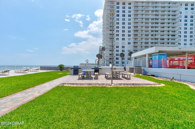 surrounding community featuring a patio area, a yard, and a water view