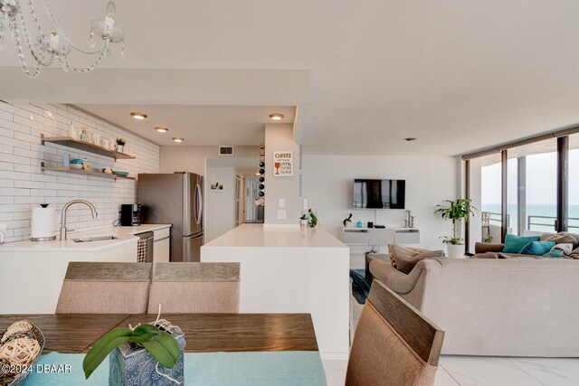 dining area featuring a chandelier, a wall of windows, and sink