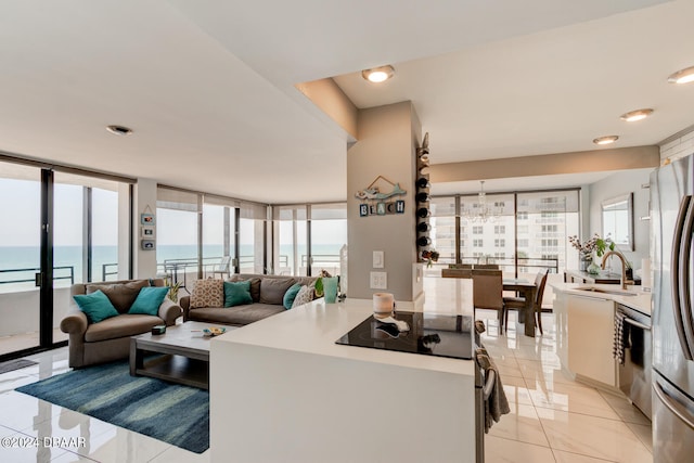 tiled living room with a water view, a wall of windows, and a wealth of natural light